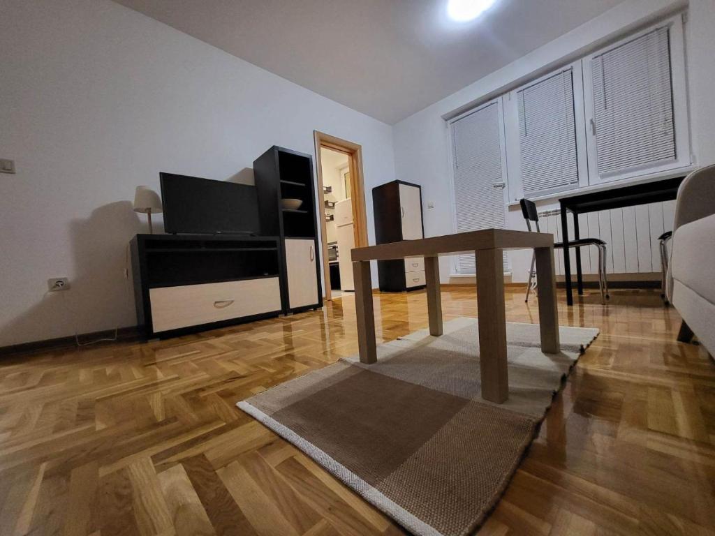 un soggiorno con TV e tavolo di Apartman Ana a Žarkovo