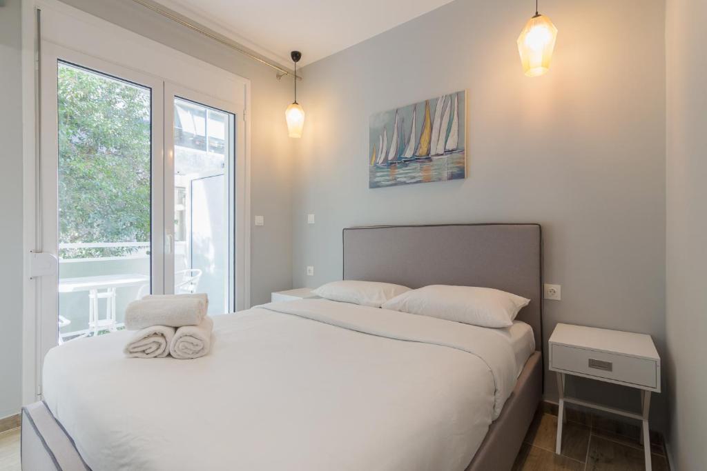biała sypialnia z łóżkiem i oknem w obiekcie Great Located Apartment For 4ppl #2 w Atenach