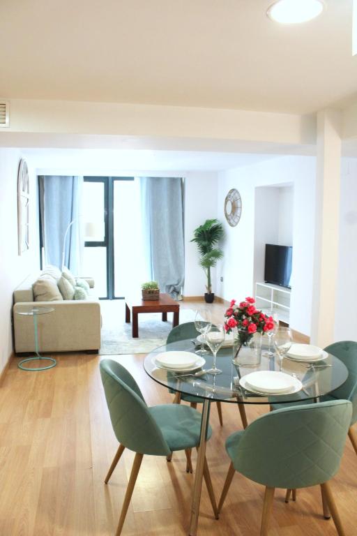 a dining room with a table and green chairs at Albareda Olehousing in Seville