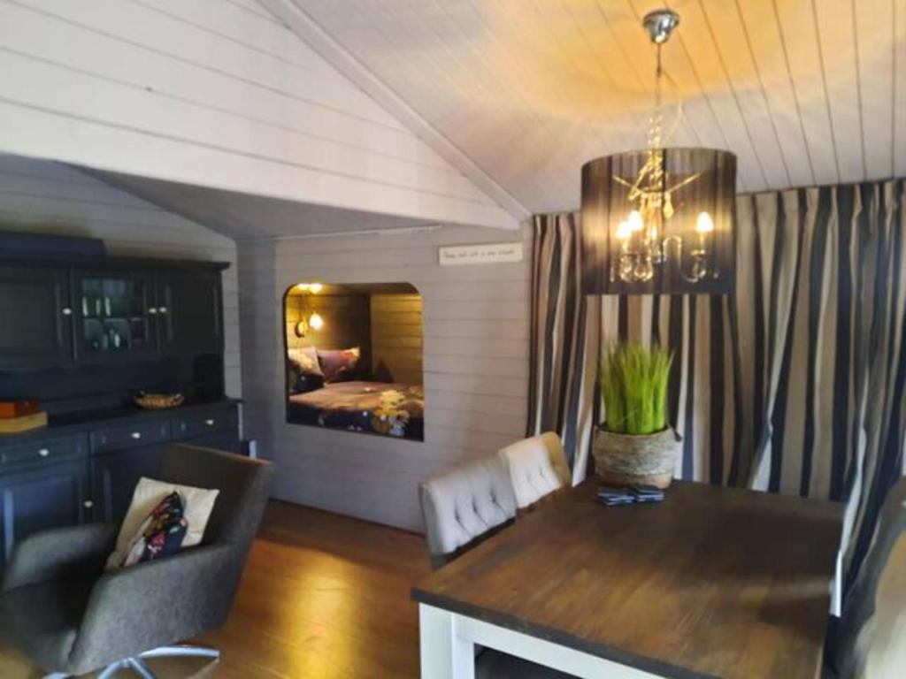 een woonkamer met een eettafel en een slaapkamer bij Prive jacuzzi cows dairyfarm relaxing sleeping in Hitzum