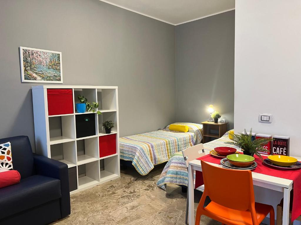 ein Wohnzimmer mit Tisch und Bett in der Unterkunft Bnbook Monolocale Beatrice Rho Fiera in Rho