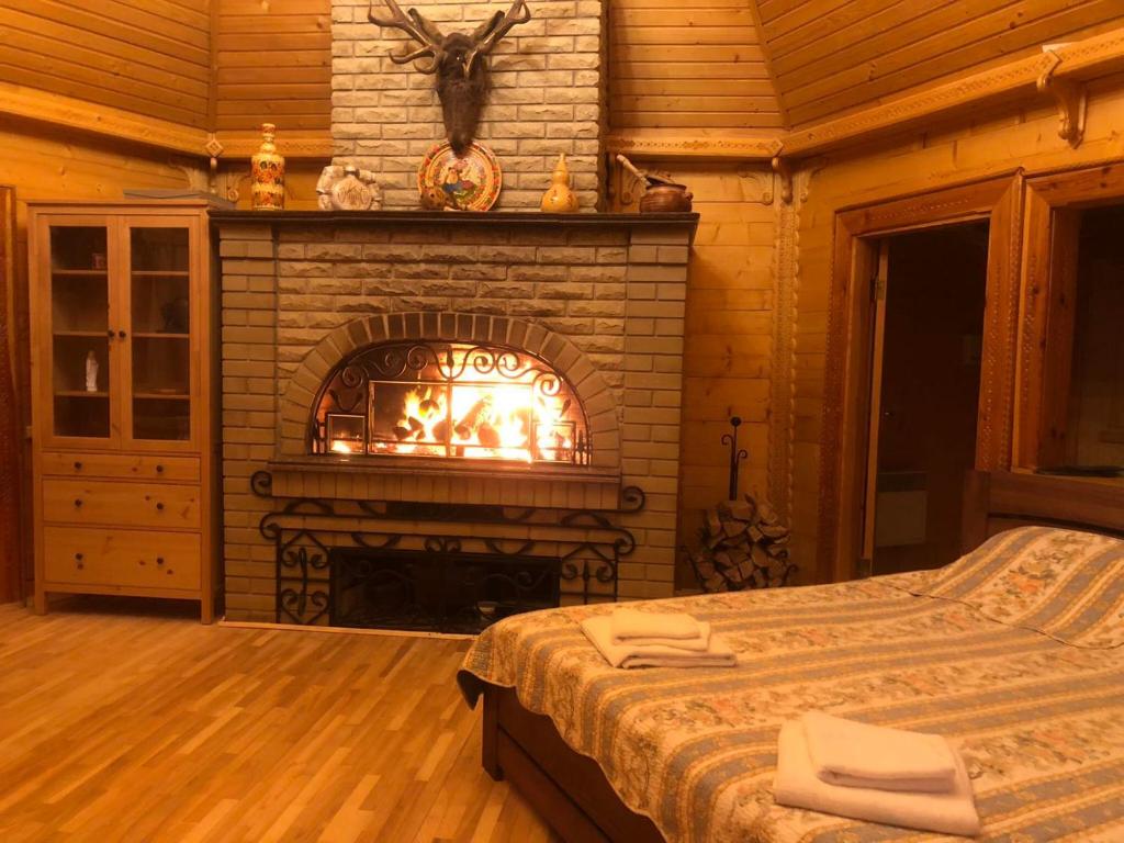 a fireplace in a bedroom with a bed in front of it at Ethno Complex Ukrayinske Selo in Buzovaya