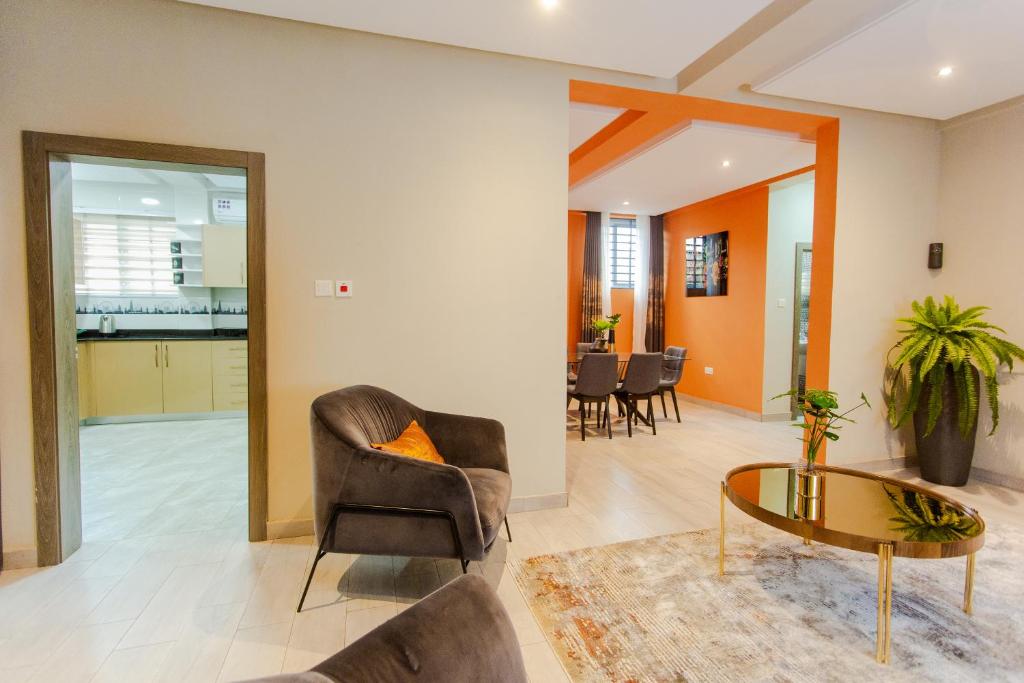 uma sala de estar com uma cadeira e uma mesa em Accra Luxury Homes @ Achimota em Lapaz