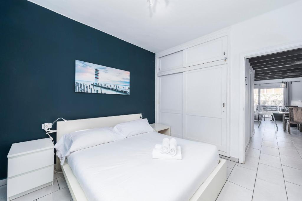sypialnia z białym łóżkiem i niebieską ścianą w obiekcie MEDANO4YOU The Bike Holiday Home w mieście El Médano