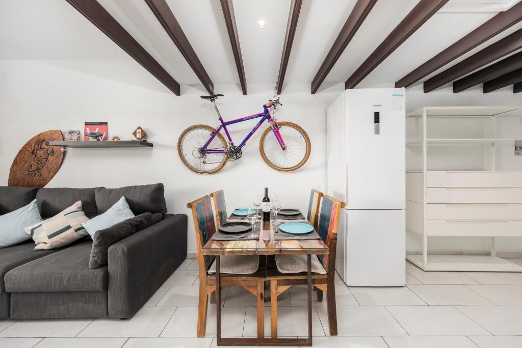 salon z kanapą i stołem z rowerem na ścianie w obiekcie MEDANO4YOU The Bike Holiday Home w mieście El Médano