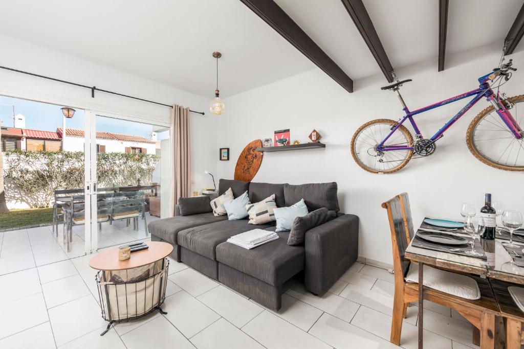 ein Wohnzimmer mit einem Sofa und einem an der Wand hängenden Fahrrad in der Unterkunft MEDANO4YOU The Bike Holiday Home in El Médano
