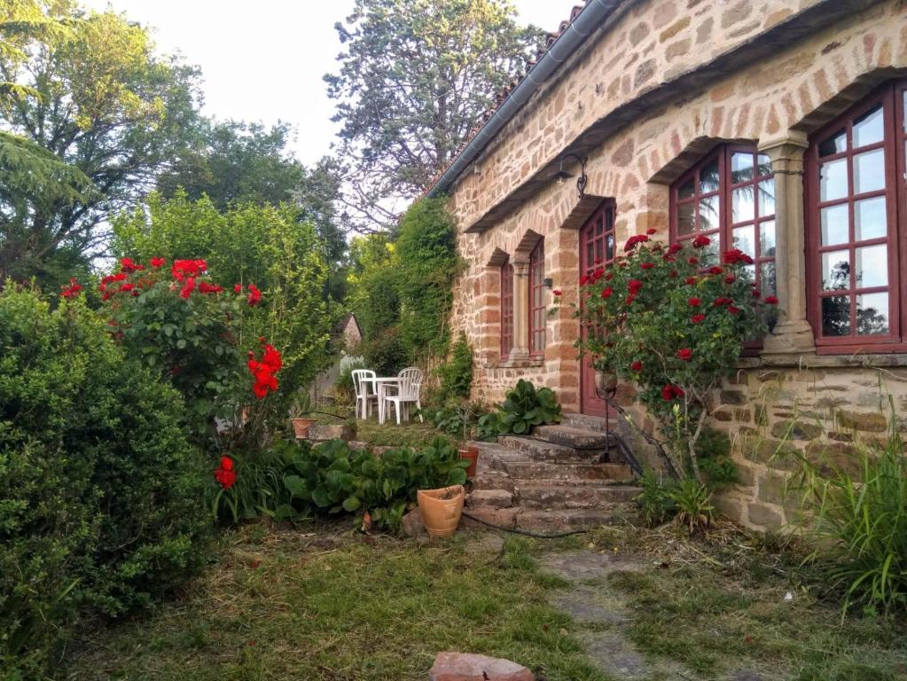 a stone house with a garden with flowers at La longère d'Anaïde in Saint Marcel Campes