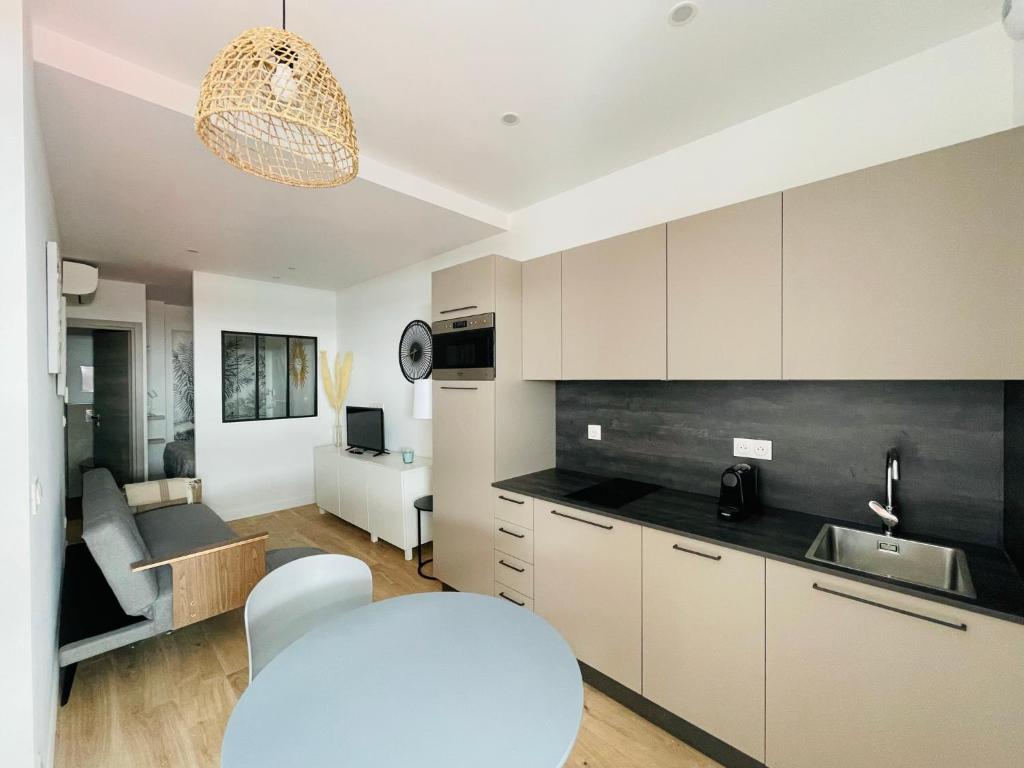 une cuisine et un salon avec une table et un canapé dans l'établissement F1 neuf TURCKHEIM TUR102, à Cannes