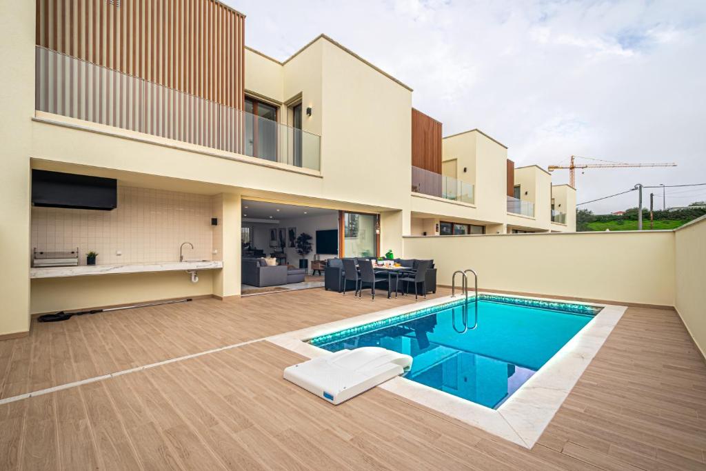 a villa with a swimming pool and a house at BeGuest Albufeira Luxus Villa in Albufeira