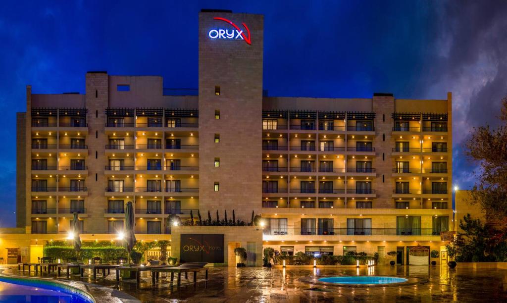 a hotel with a sign on top of a building at Oryx Hotel Aqaba in Aqaba