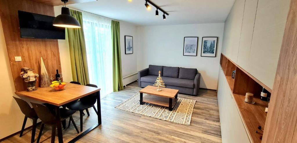 una sala de estar con una mesa y un sofá en Popović apartmani, Sunčani breg, en Kopaonik