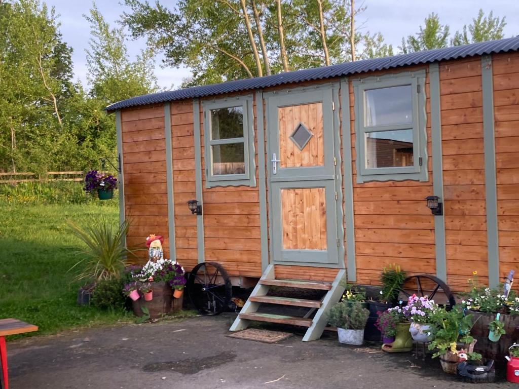 a tiny house with a door and some plants at Captivating 1-Bed Cabin in Middlesbrough in Middlesbrough