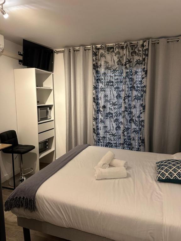 1 dormitorio con 1 cama y una ventana con cortinas en CALME-APPARTEMENT en La Grande-Motte