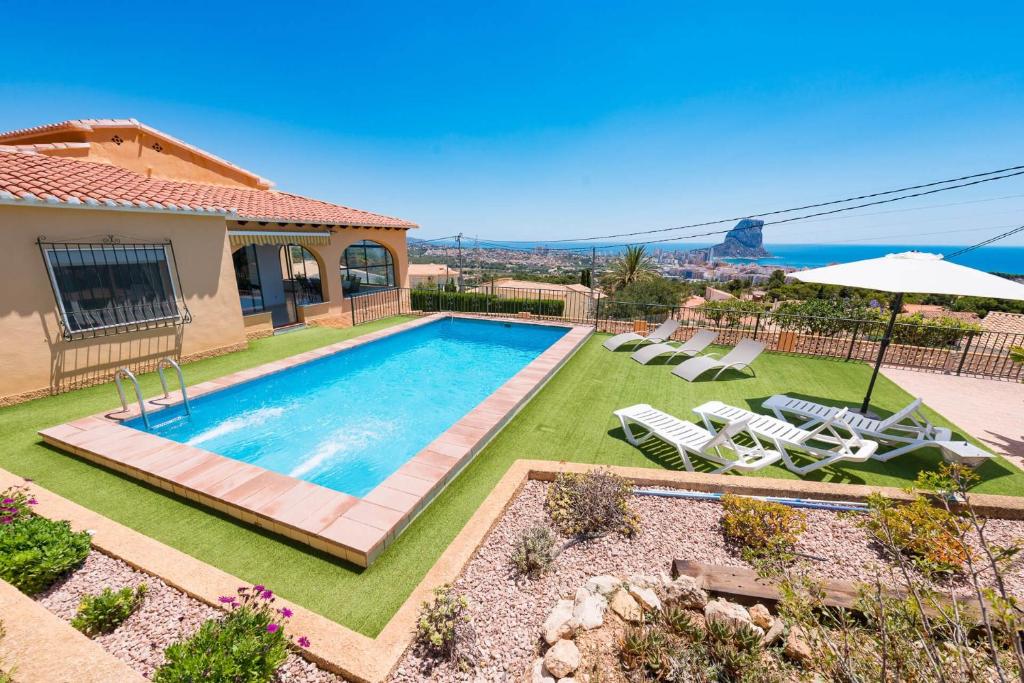 a swimming pool in a yard with a house at Villa Andres - PlusHolidays in Calpe