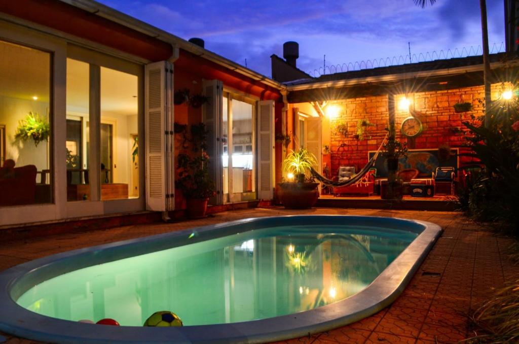 a swimming pool in front of a house at night at Pelotas Bier Hostel in Pelotas