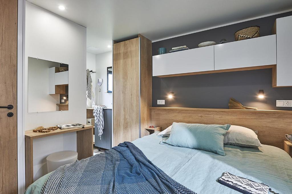 a bedroom with a bed and a desk at CAMPING Bassin Arcachon - LES GOELANDS in Arès