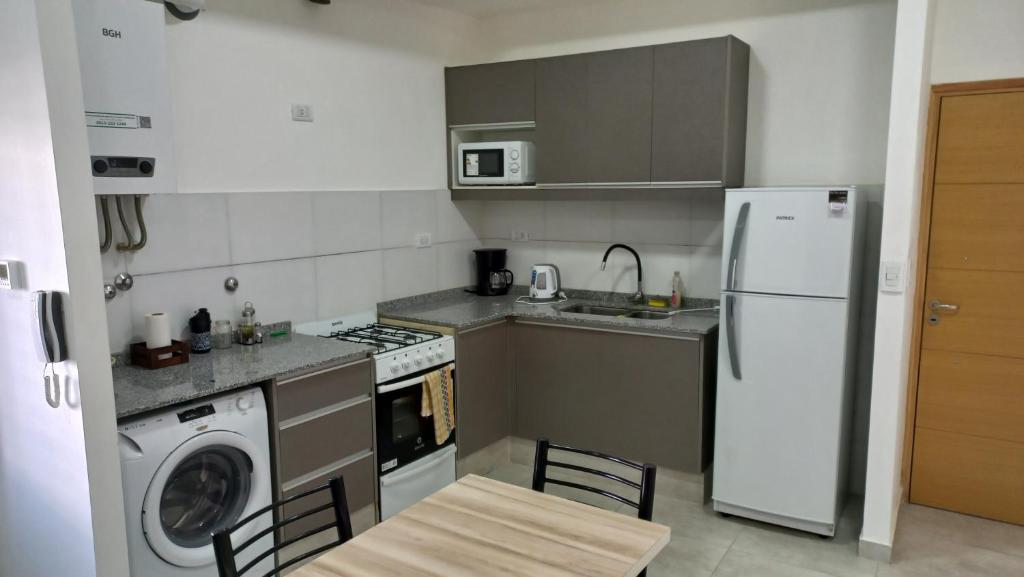 a kitchen with a white refrigerator and a dishwasher at S1 Cálido departamento para conocer Mendoza in Godoy Cruz