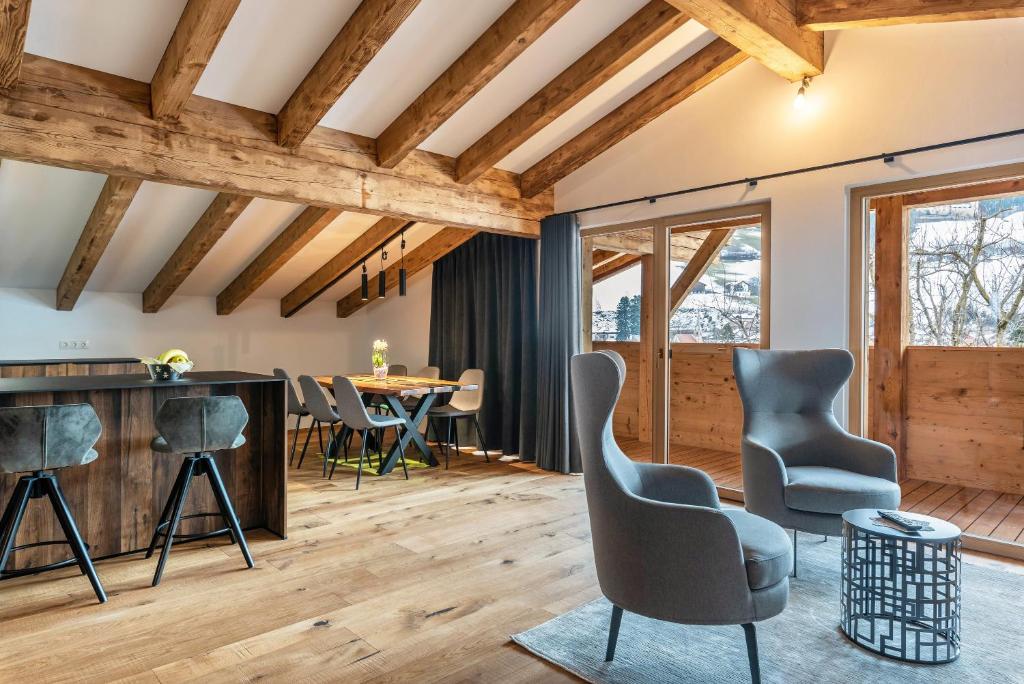 ein Wohnzimmer mit Holzdecken, Stühlen und einem Tisch in der Unterkunft Alpin Chalet Samer Apt Fürstenblick in Sarntal