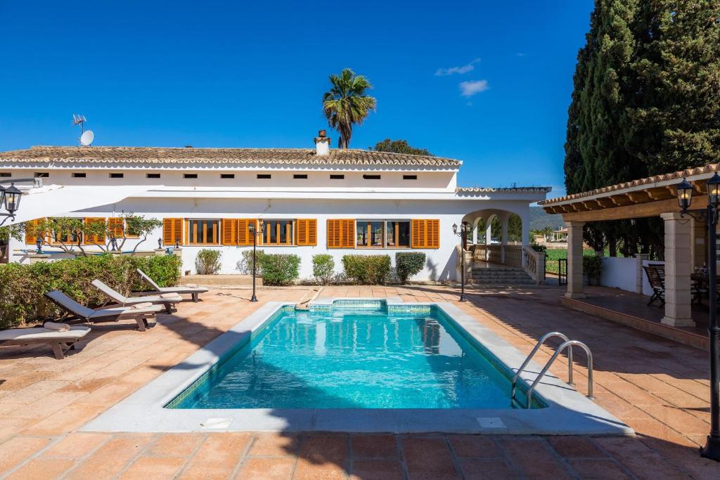 a swimming pool in front of a house at Son Valenti in Sa Pobla