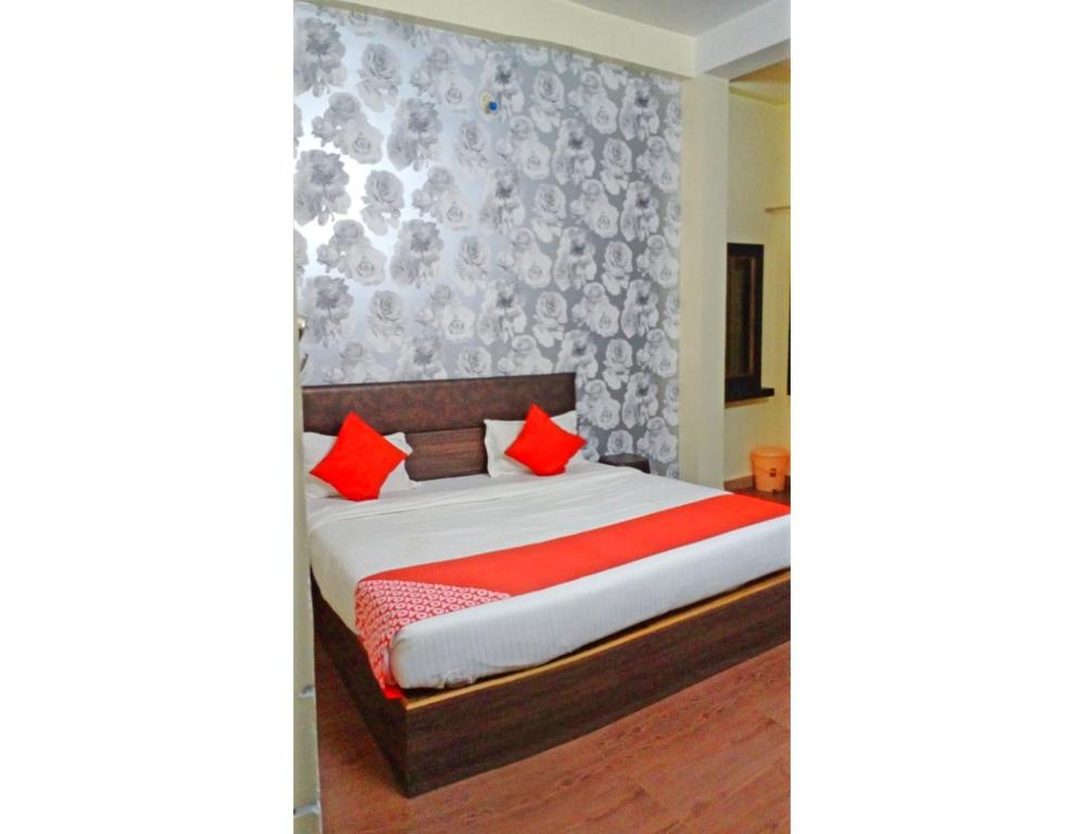 1 dormitorio con 1 cama con almohadas rojas en Hotel Shanti Heritage, Guna, en Guna