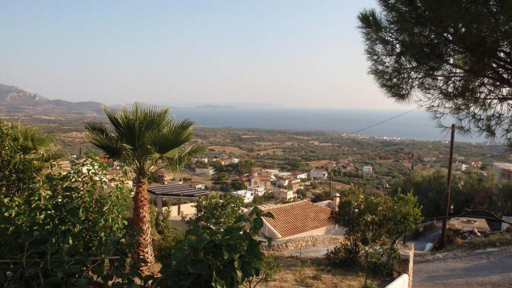 a view of a town with a palm tree and the ocean at Soubassis House in Elíka