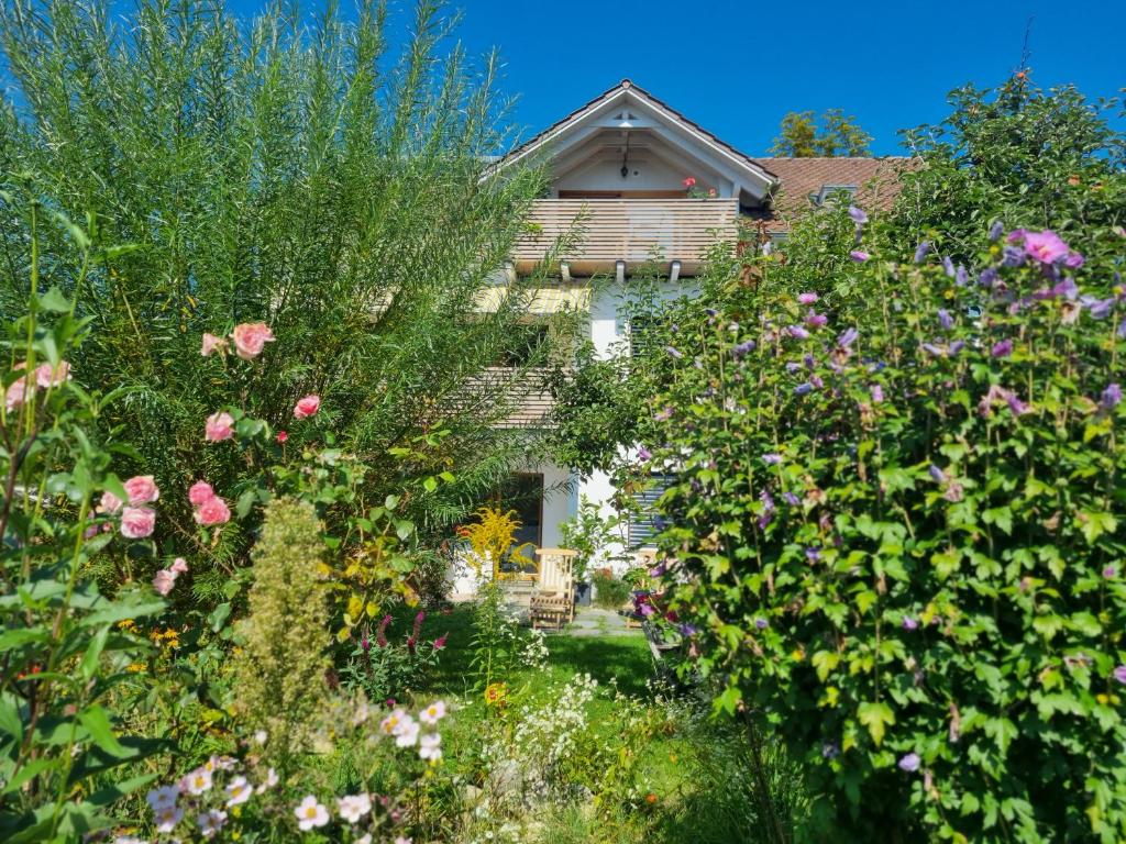 uma casa com um jardim de flores em frente em Traumhafte Gartenwohnung in Überlinger Hanglage - Zur goldenen Kiwi em Überlingen