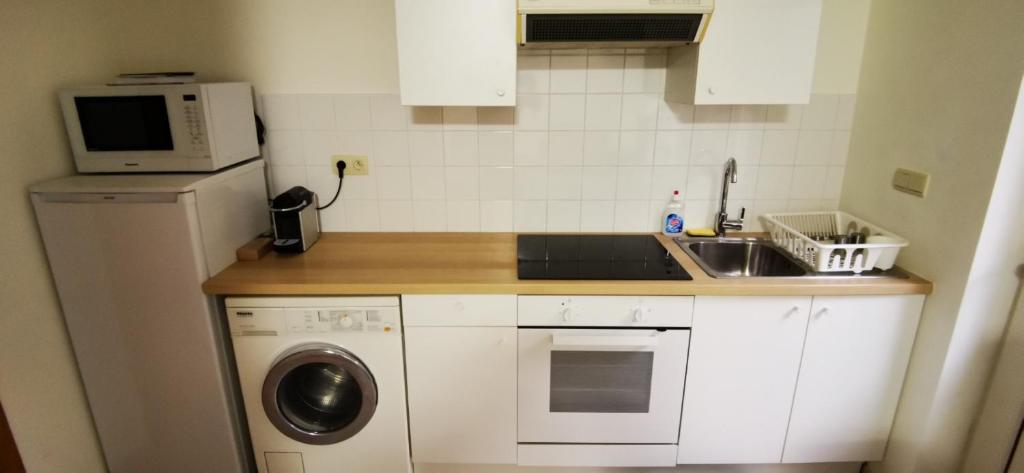 a small kitchen with a sink and a microwave at Studio équipé Brussels in Sint-Pieters-Leeuw