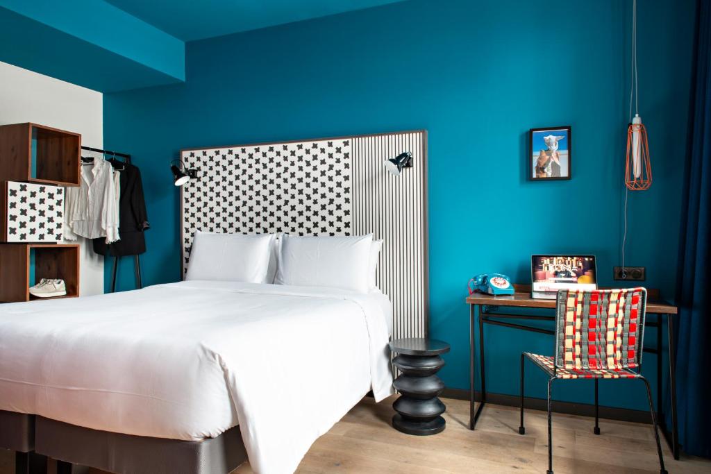ストラスブールにあるBOMA easy living hotelの青いベッドルーム(ベッド1台、テーブル、椅子付)
