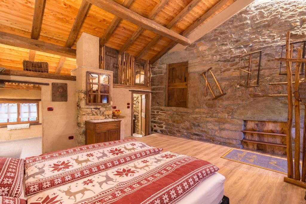 a bedroom with a bed and a stone wall at La Mason dla Grà in Frassinetto