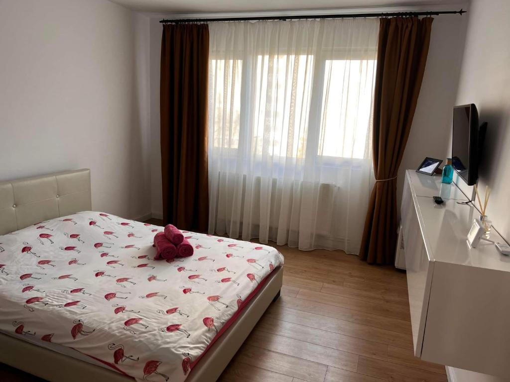 Un dormitorio con una cama con un osito de peluche. en Garsoniera Flamingo Garii 4 en Brasov