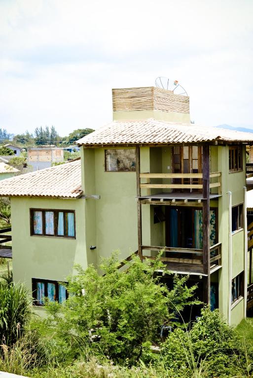 a green building with a roof on top of it at Pousada Praia Verde in Imbituba