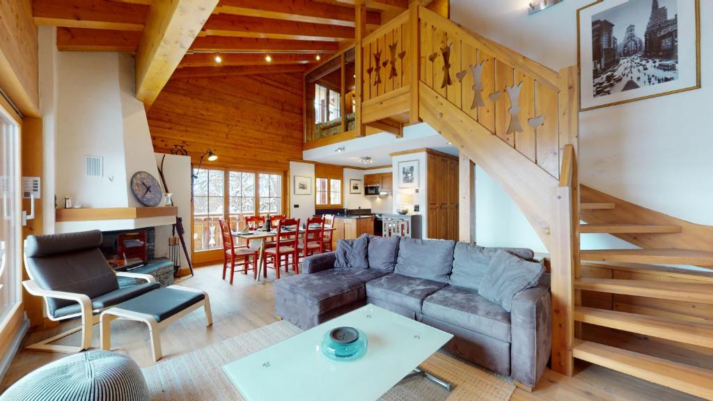 a living room with a couch and a staircase at Terrasses du Paradis 7A LUXE & CENTER apart 8 pers in Nendaz
