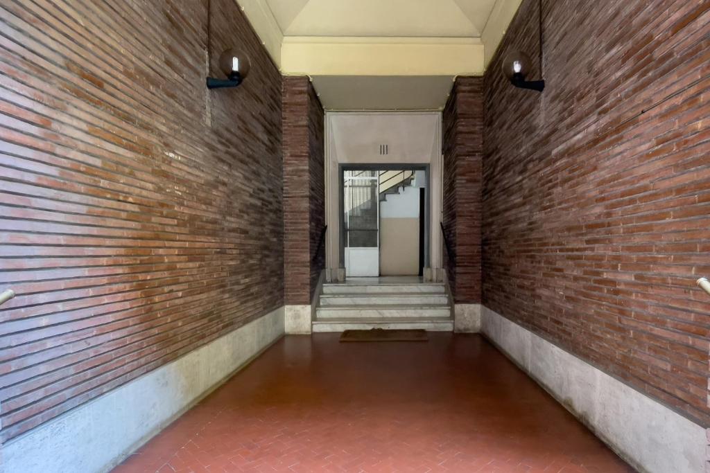 un couloir vide avec un mur en briques dans l'établissement Piazza San Pietro Suite, à Rome