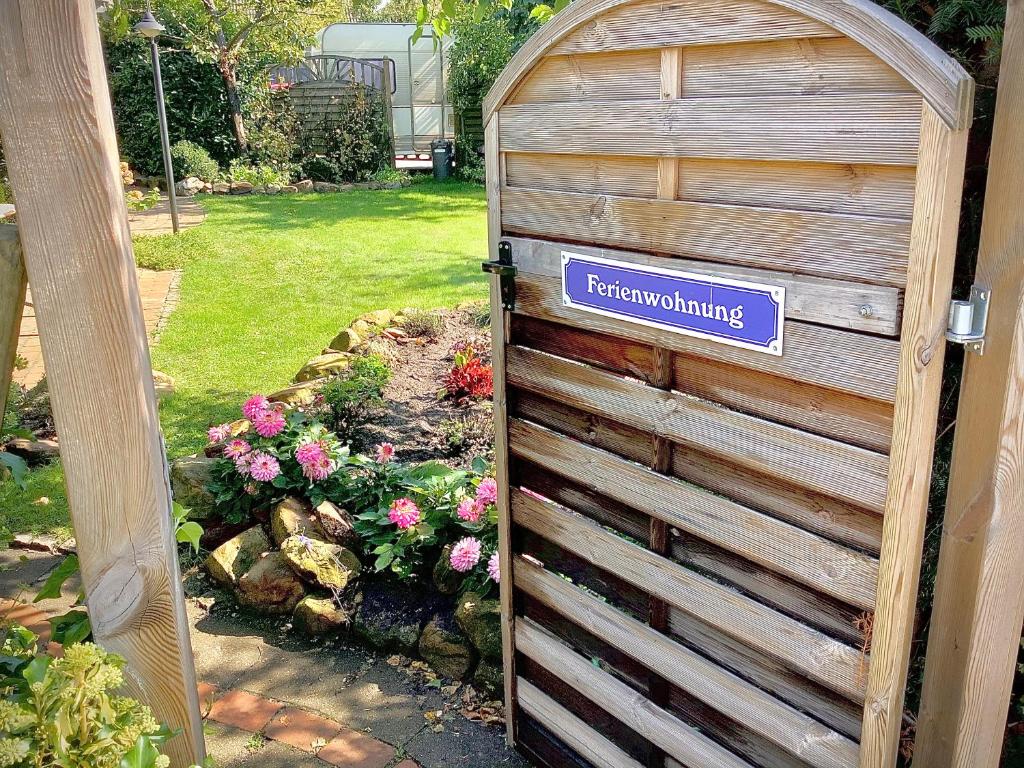 a wooden gate with a sign that reads enchanting at Spechtstraße 65 Ferienwohnung in Nordhorn