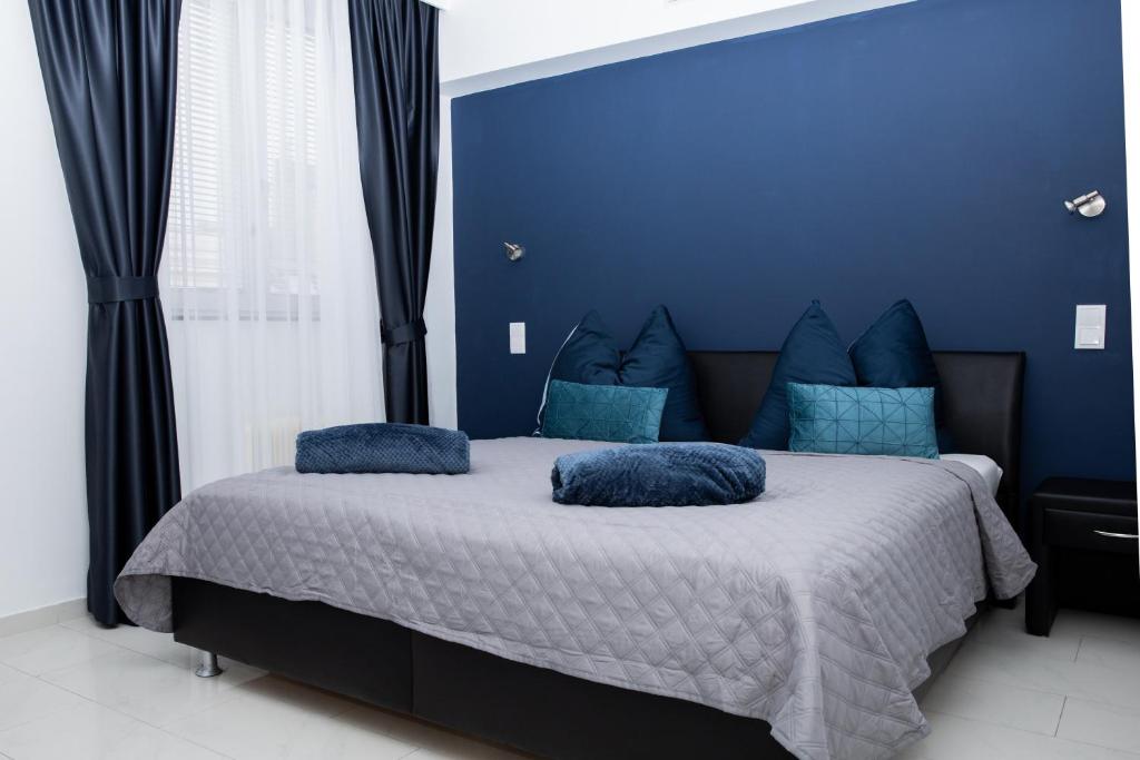 a blue bedroom with a large bed with blue pillows at Vladys Vienna Apartments in Vienna