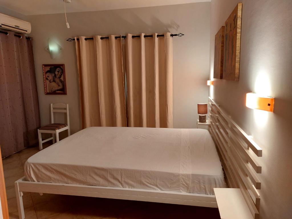 een slaapkamer met een wit bed en gordijnen bij Apartamento Antunes in Santa Maria