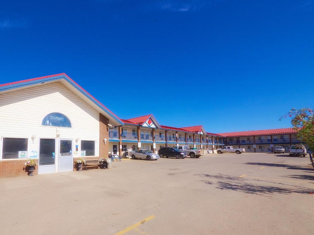 un grand parking en face d'un motel dans l'établissement BCMInns - Fort McMurray - Rusty's, à Fort McMurray