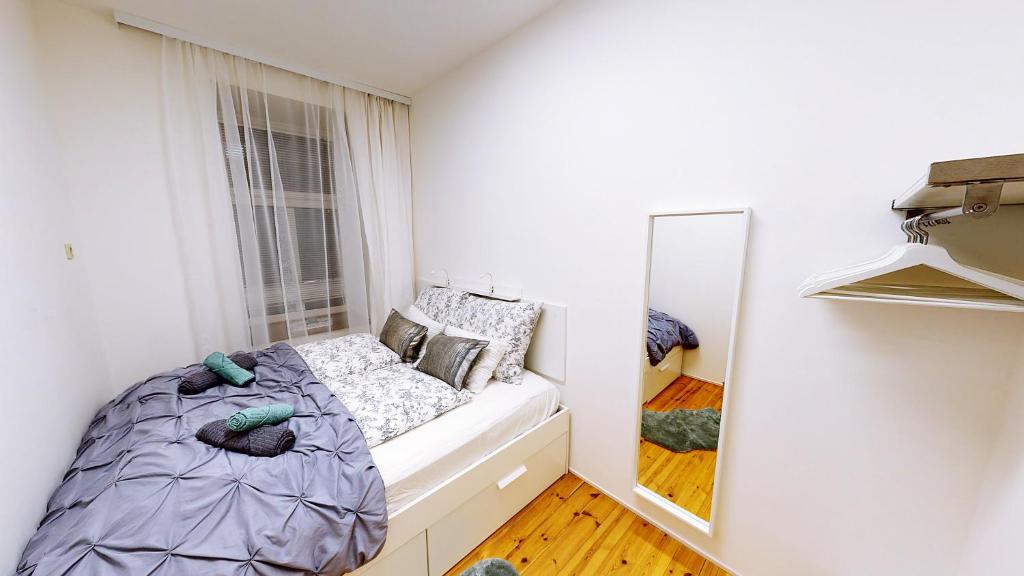 małą sypialnię z łóżkiem i lustrem w obiekcie Apartment Wood w Wiedniu
