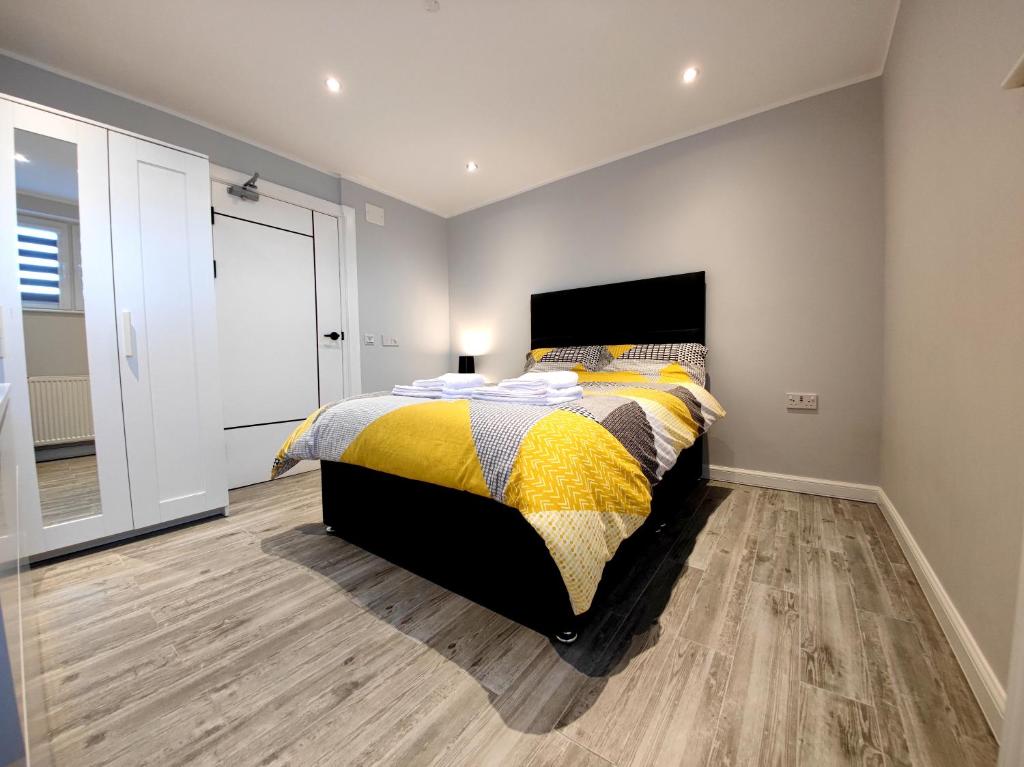 a bedroom with a bed with a yellow and black comforter at Private Room in Exclusive Apartment in Aberdeen