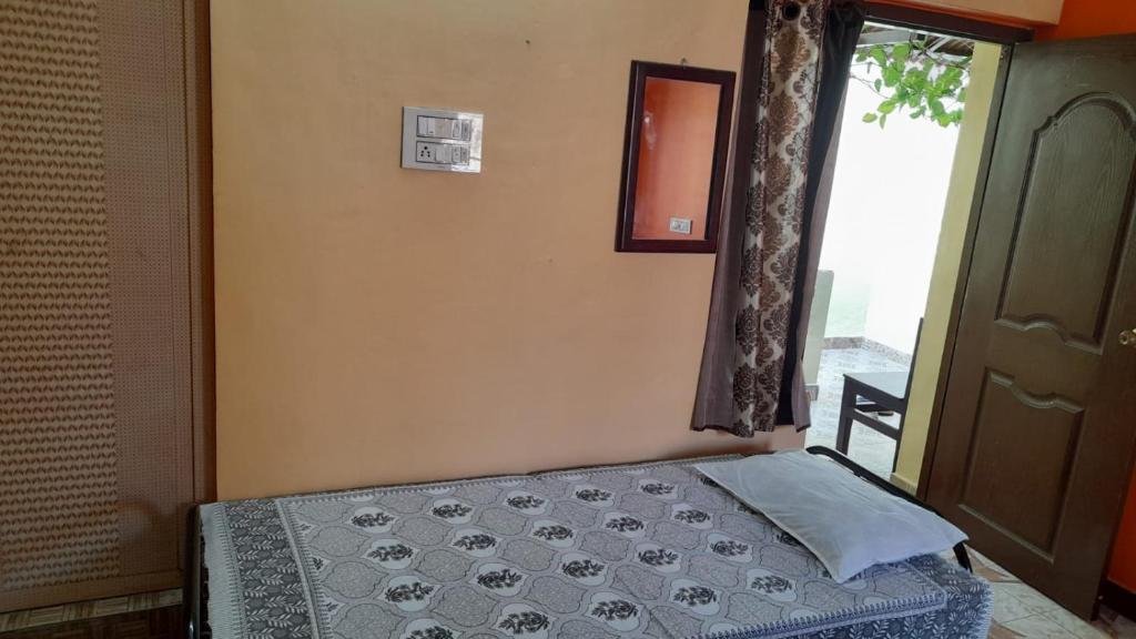 VILLA UMAR HOMESTAY في بونديتْشيري: غرفة نوم صغيرة بها سرير ونافذة