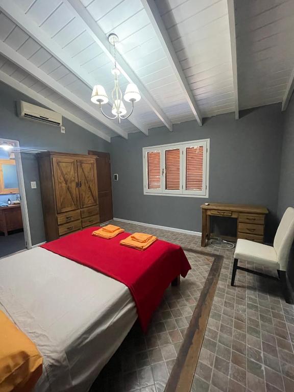 una camera da letto con un grande letto con una coperta rossa di Casitas El Lago a Carhué