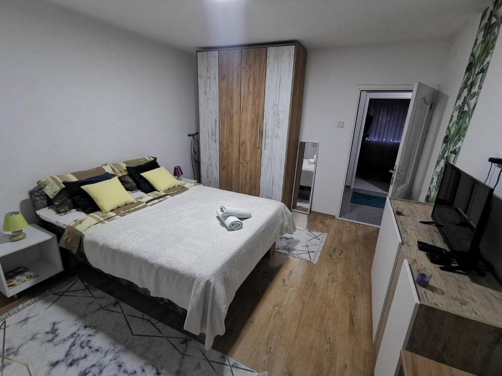 a bedroom with a large bed and a television at Teslić Apartman NiA in Teslić