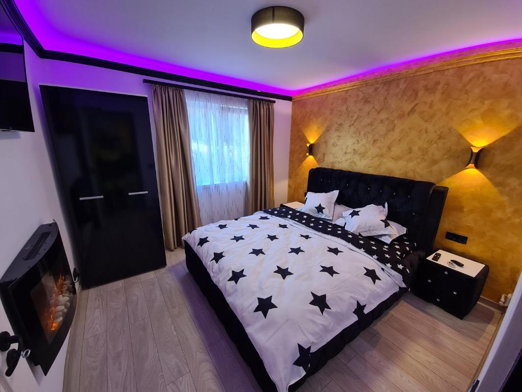 ein Schlafzimmer mit einem Bett mit schwarzen Sternen darauf in der Unterkunft Diamonds House 2 in Lupeni