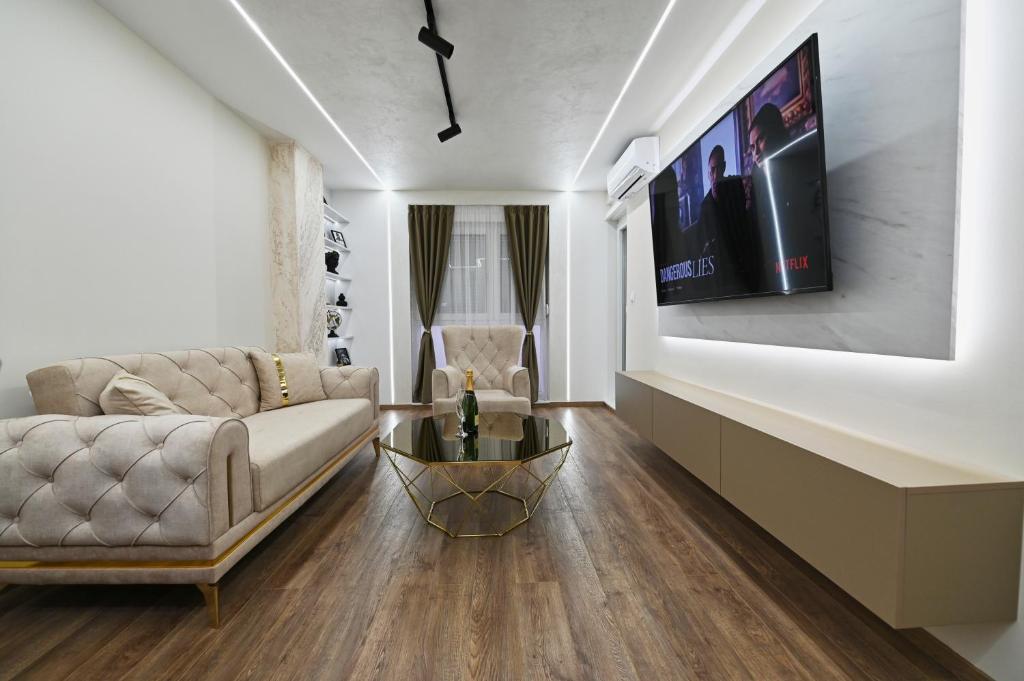 - un salon avec un canapé et une télévision murale dans l'établissement Apartman 52, à Doboj