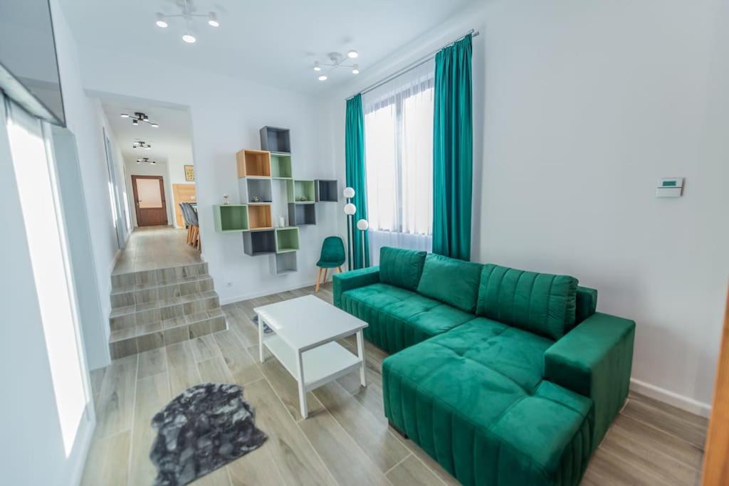 a living room with a green couch and a table at CasiAna Apartment in Râşnov
