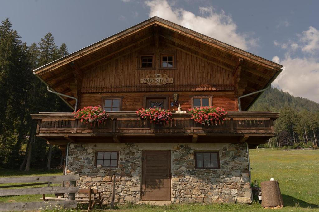 a log cabin with flowers on the balcony at Ferienhaus Moosstadel in Patriasdorf