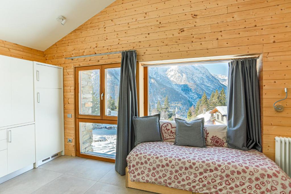 a bedroom with a bed and a large window at Baita sulle piste in Valmalenco in Chiesa in Valmalenco