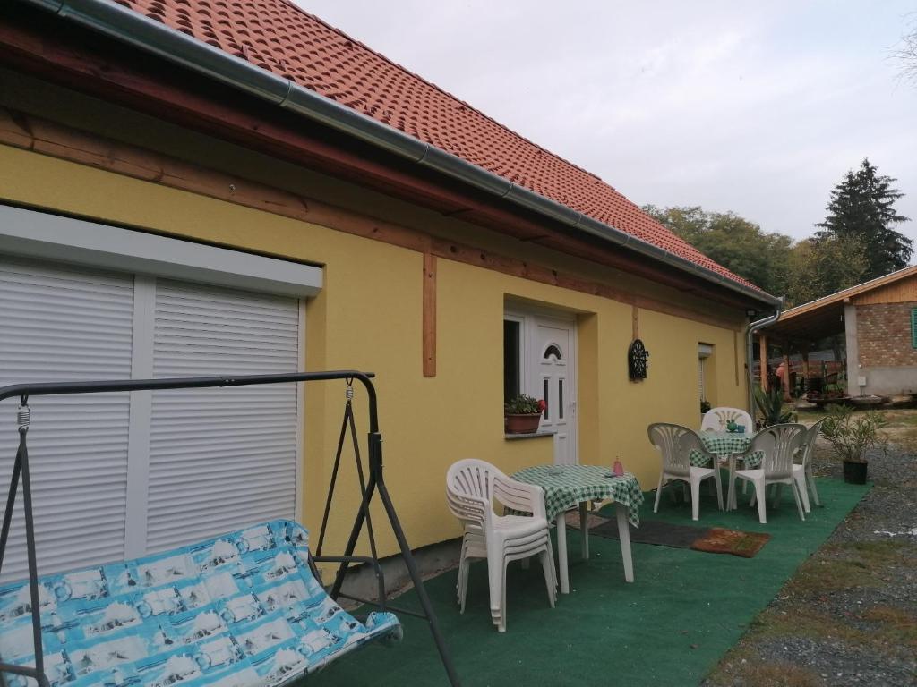 a patio with chairs and tables on a house at Berkenyés Vendégház in Zalalövő