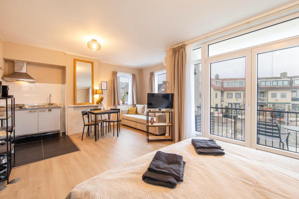 een kamer met een bed, een keuken en een woonkamer bij Blankebil Studios & Apartments in Zandvoort