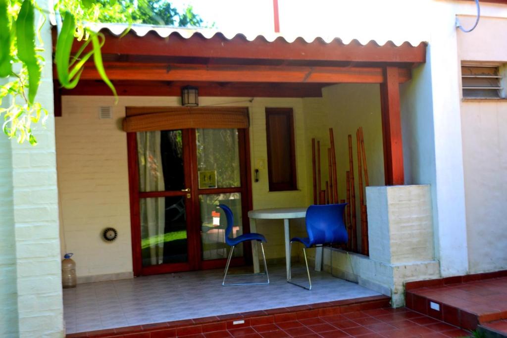 a patio with two chairs and a table on a house at CABAÑAS TERRAZAS CHASCOMUS II in Chascomús